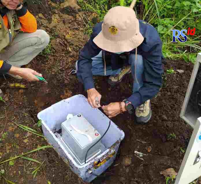 Petugas Pengamatan Gunung Api (PGA) Sindoro- Sumbing saat memasang kembali aki sebagai pengisi daya alat seismik kemarin. (Istimewa)
