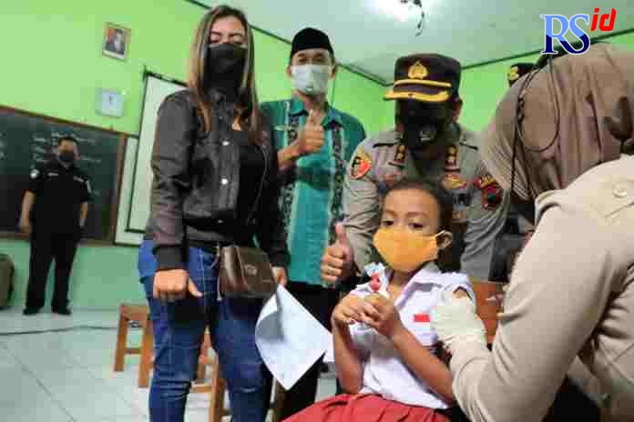 Salah satu anak di SD Rejowinangun Utara mendapatkan permen sebelum divaksin tim Dokkes Polres Magelang Kota. (Istimewa)