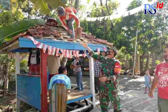 Warga dan TNI bergotong royong merenovasi gardu pos kamling. (WAHIB PRIBADI/JAWA POS RADAR SEMARANG)