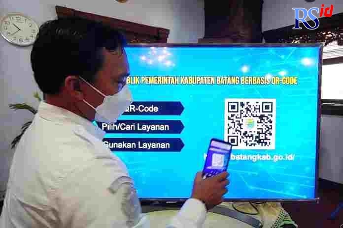 Bupati Batang Wihaji saat mencoba melakukan scan kode QR pusat layanan informas. i(RIYAN FADLI/JAWA POS RADAR SEMARANG)