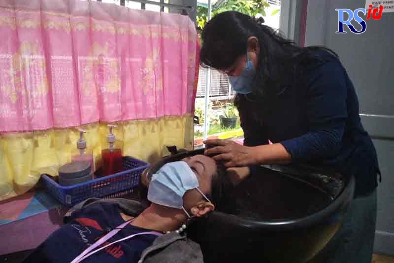 Napi N saat melayani jasa cuci rambut di Salon Putri Mandiri. (IDA FADILAH/JAWA POS RADAR SEMARANG)