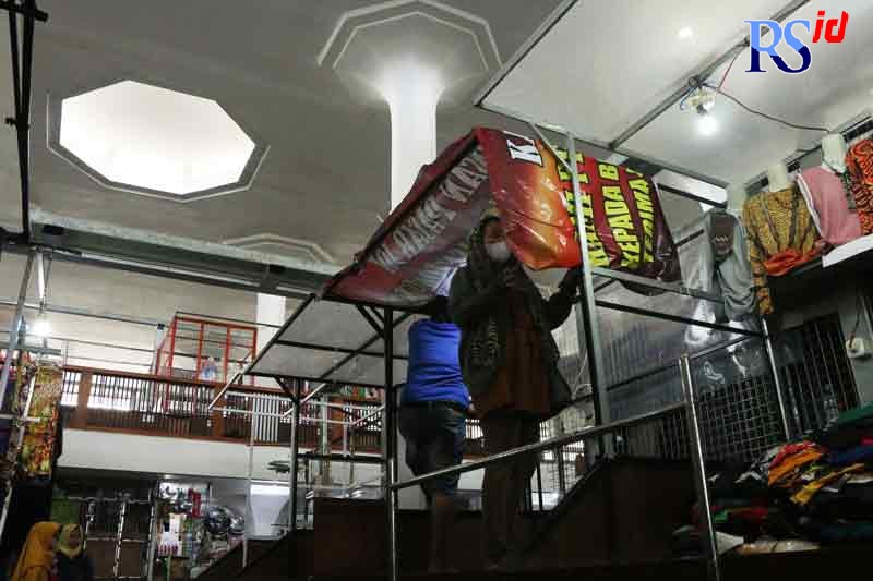 Pedagang Johar menutupi lapaknya dengan MMT agar dagangannya tidak basah. (NUR CHAMIM/JAWA POS RADAR SEMARANG)