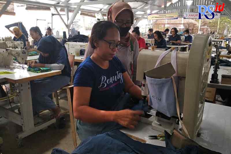 Acih, salah satu napi narkoba saat menyelesaikan pesanan jaket didampingi supervisor Amura Pratama. (IDA FADILAH/JAWA POS RADAR SEMARANG)