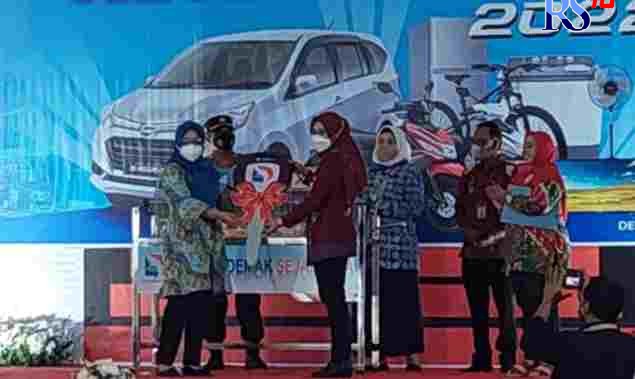 Bupati Demak dr Eistianah didampingi Dirut PT LKM Demak Sejahtera Eni Suprapti menyerahkan kunci mobil secara simbolik untuk pemenang hadiha utama gebyar undian rejeki Tapas. (Wahib Pribadi/Jawa Pos Radar Semarang)  