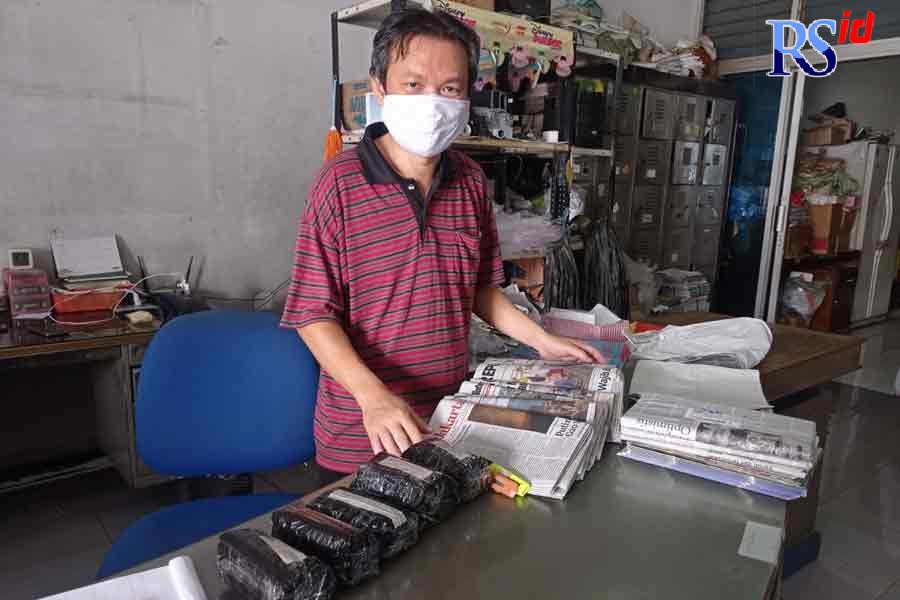 Antonius Riyanto saat menata koran harian di agen koran miliknya Jalan Erlangga No 24, Pleburan, Semarang. (KHAFIFAH ARINI PUTRI/JAWA POS RADAR SEMARANG)