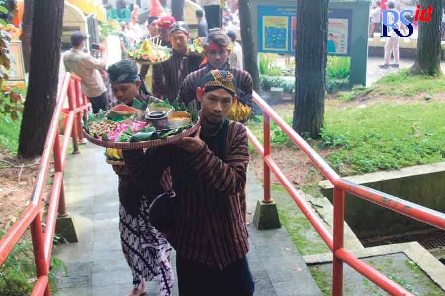 Warga membawa nasi berkat menaiki anak tangga di Kebun Raya Gunung Tidar dalam acara ruwatan sedekah bumi Kamis (24/3). (ROFIK SYARIF G P/JAWA POS RADAR SEMARANG)