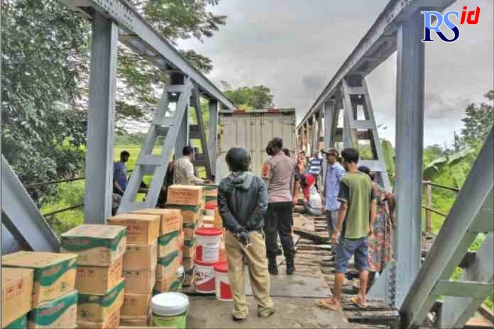 TERJEBAK: Proses evakuasi truk boks yang terjebak di jembatan poros Bojong - Sragi, beberapa waktu lalu. (IST)