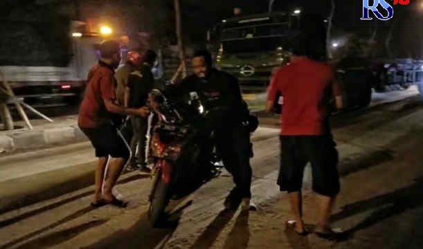 Seorang pemotor terjatuh terpeleset ceceran lumpur di Jalan Arteri Yos Sudarso, persisnya di sekitaran kawasan Pantai Cipta, Banjarharjo, Semarang Utara, Rabu (11/5/2022) malam. (M Haryanto/Jawa Pos Radar Semarang)