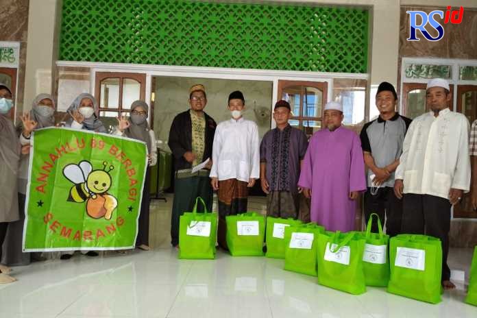 Nur Fatmawati bersama Annahlu 89 Berbagi menyerahkan bingkisan untuk marbot di Kaligawe. (KHAFIFAH ARINI PUTRI/ JAWA POS RADAR SEMARANG)