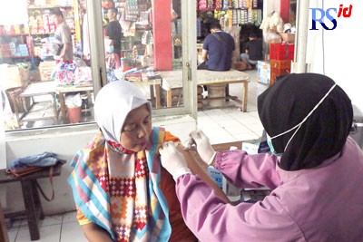 Petugas dari Puskesmas Kedungmundu saat melakukan vaksinasi kepada pedagang Pasar Kapling. (NUR CHAMIM/ JAWA POS RADAR SEMARANG)