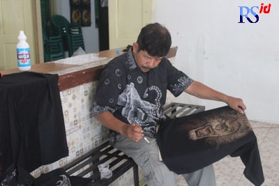 Wusriyanto saat sedang melukis menggunakan bayclin pada sebuah kaos gelap. (ROFIK SYARIF G P/JAWA POS RADAR SEMARANG)
