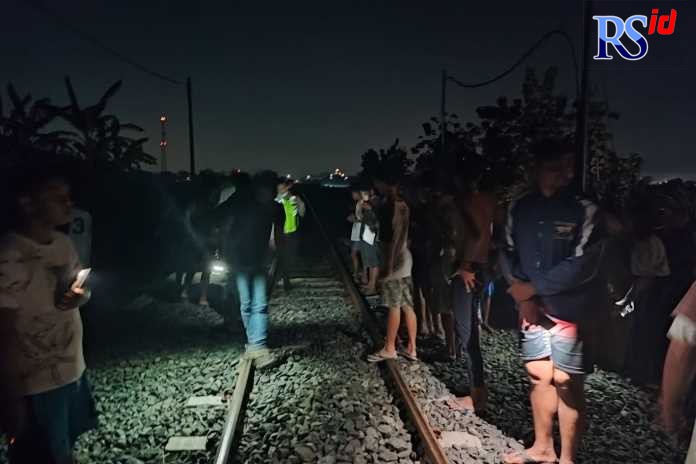 Caption:Petugas dan warga menunjukkan lintasan rel KA tempat tertabraknya orang sakit jiwa oleh KA Brantas.(Wahib Pribadi/Jawa Pos Radar Semarang)