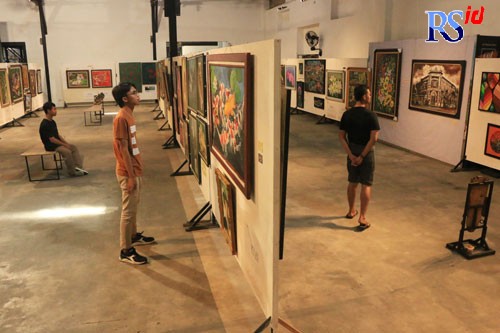 Sejumlah pengunjung menikmati karya seni rupa di Gedung Industri Kreatif Kota Lama, Senin (4/7). (NUR CHAMIM/ JAWA POS RADAR SEMARANG)