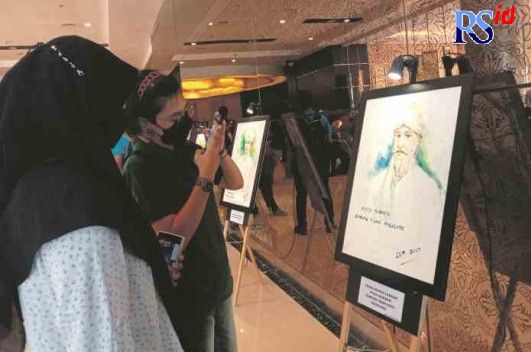 VISUALISASI PENELUSURAN : Pengunjung menyaksikan lukisan Gus Soleh Pati yang dipamerkan di Hotel Atria Magelang, Jumat (1/7). (NOVA NUR AFIFAH/JAWA POS RADAR MAGELANG)