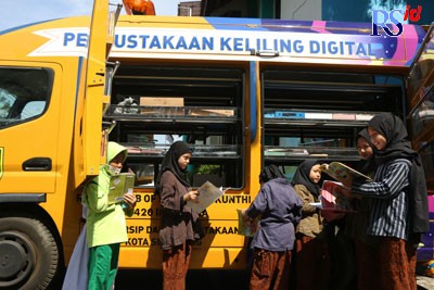 Peserta didik SD Islam Al-Azhar mengerubungi perpustakaan mobile untuk membaca buku yang disukai di SD Islam Al-Azhar 14 Semarang, Selasa (27/9). (NUR CHAMIM/JAWA POS RADAR SEMARANG)