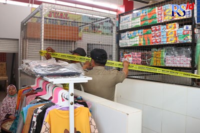Petugas Satpol PP Kota Semarang memasang pita segel di lapak yang ditinggalkan pedagang. (NUR CHAMIM/JAWA POS RADAR SEMARANG)