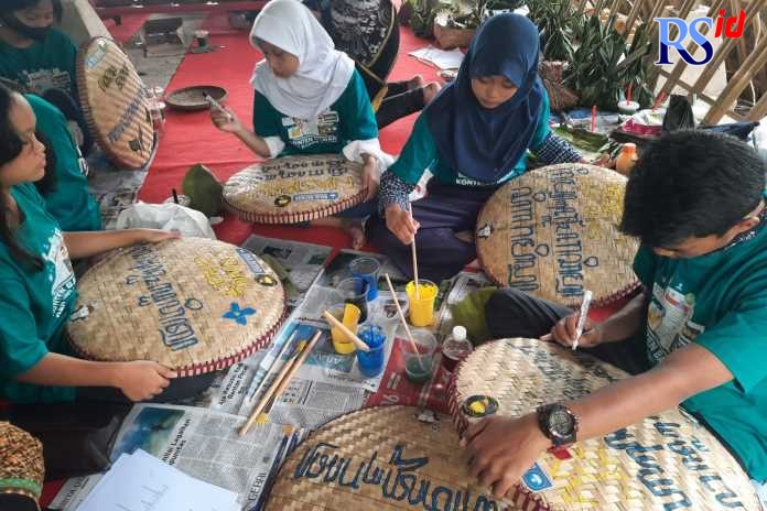 Anak-anak menulis aksara Jawa di tampah dalam acara bengkel literasi yang berlangsung di panggung Pasar Kuliner Tradisional, Embung Sebligo, Desa Wisata Lerep, Ungaran Minggu (4/9/2022). (Istimewa)