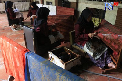 Para pekerja penuh kesabaran membatik kain dengan corak kearifan lokal dengan canting. (NUR CHAMIM/JAWA POS RADAR SEMARANG)