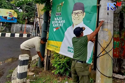 Anggota Satpol P3KP saat mencopot salah satu baliho usang pada Selasa (11/10). (Lutfi Hanafi/Jawa Pos Radar Semarang)