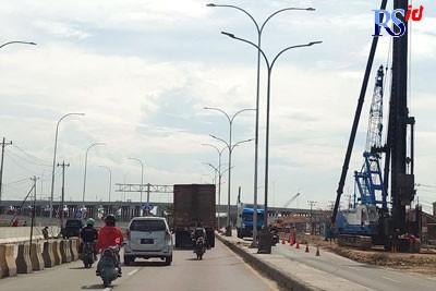 Sebuah alat berat digunakan untuk menyelesaikan ujung jalan exit tol Sidogemah Sayung. (Wahib Pribadi/Jawa Pos Radar Semarang)