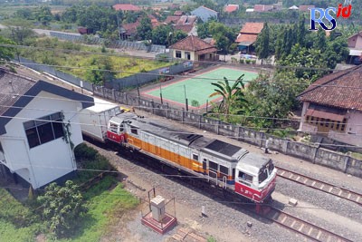 Kereta api melintasi di bawah jembatan flyover Ganefo Mranggen. (Wahib Pribadi/Jawa Pos Radar Semarang)