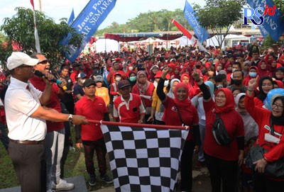 Kepala DP3A Kota Semarang Ulfi Imran Basuki didampingi Direktur Jawa Pos Radar Semarang Baehaqi dan sejumlah kepala OPD Pemkot Semarang mengibarkan bendera start tanda dimulainya jalan sehat di Lapangan Embung Wonololo, Kecamatan Mijen, Kota Semarang, Min