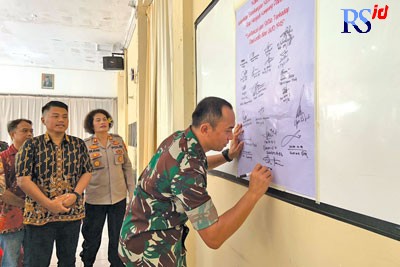 Komandan Kodim 0733/Kota Semarang Letkol Inf Honi Havana membubuhkan tanda tangan saat peluncuran Kampung Pancasila di RW 03 Kelurahan Bendungan. (KHAFIFAH ARINI PUTRI/JAWA POS RADAR SEMARANG)