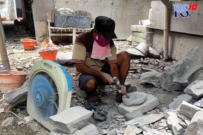 Warsito berhati-hati dan teliti saat membuat cobek batu di samping rumahnya. (DEVI KHOFIFATUR RIZQI/ JAWA POS RADAR SEMARANG)