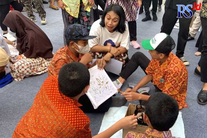 Menteri PPPA I Gusti Ayu Bintang Darmawati ketika berinteraksi dengan sejumlah pelajar yang tengah belajar membatik. (Khafifah/Jawa Pos Radar Semarang)