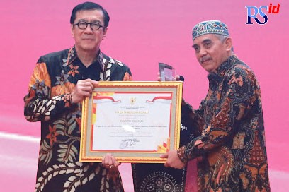 Menteri Hukum dan HAM RI Yasona H Laoly menyerahkan penghargaan pada Sekretaris Daerah Kabupaten Wonosobo One Andang Wardoyo Selasa (18/10). (Istimewa)