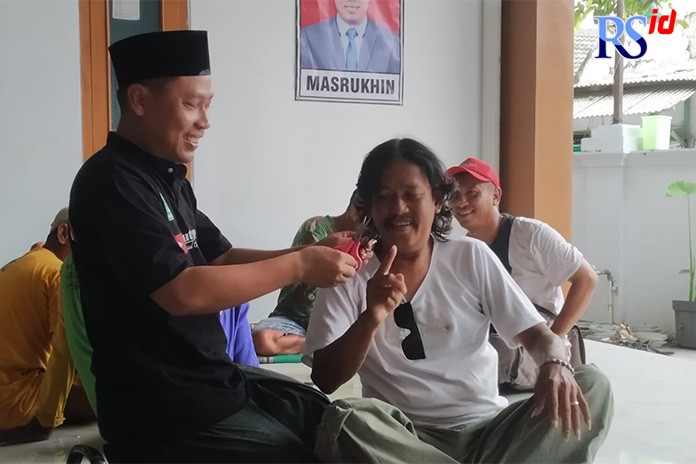 MENANG: Kades terpilih Desa Botorejo, Kecamatan Wonosalam, Masrukhin, memotong rambut simpatisannya yang bernadzar potong rambut setelah memenangi pilkades. (WAHIB PRIBADI/JAWA POS RADAR SEMARANG)