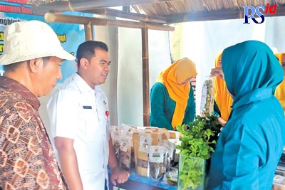 Juri dari Dinas Koperasi dan UMKM Kota Semarang Rahmad Aji Maulana mendengarkan penjelasan tentang produk UMKM dari RW 15 Kelurahan Tanjung Mas, Kecamatan Semarang Utara. (Ridwan Tri Anggoro/Jawa Pos Radar Semarang)