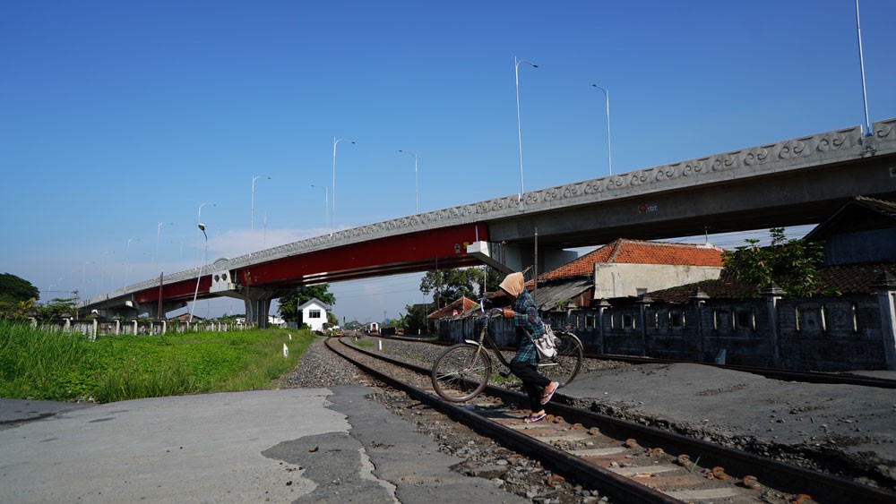 Warga melintasi perlintasan kereta api dibawah Fly Over Ganefo Senin (29/11/2022). Pembangunan Fly Over Ganevo oleh Pemprov Semarang diharapkan memecah kemacetan, yang terjadi di ruas tersebut selama bertahun-tahun. Pembangunan jembatan layang yang menela