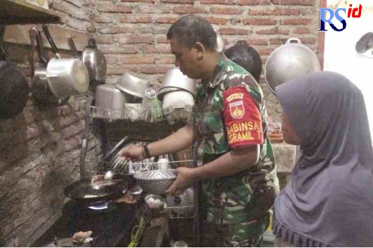 TENTARA MASUK DAPUR: Babinsa Koramil 7 Wonopringgo Kodim 0710 Pekalongan Pelda Sudiro saat mulai menggoreng tempe untuk keluarga Sagi-Sutarmi, Jumat (4/11).