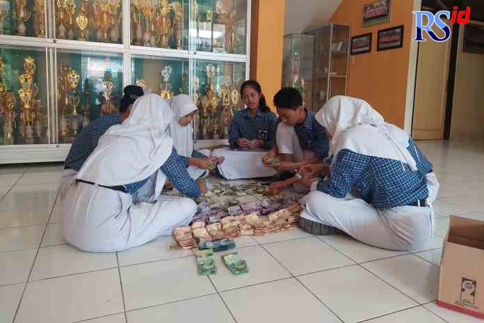 SOLIDARITAS : Para siswa SMPN 6 Temanggung saat menghitung uang yang terkumpul dari galang dana setelah upacara Hari Guru Jumat (25/11). (ADDIN ALFATH/ JAWA POS RADAR MAGELANG)