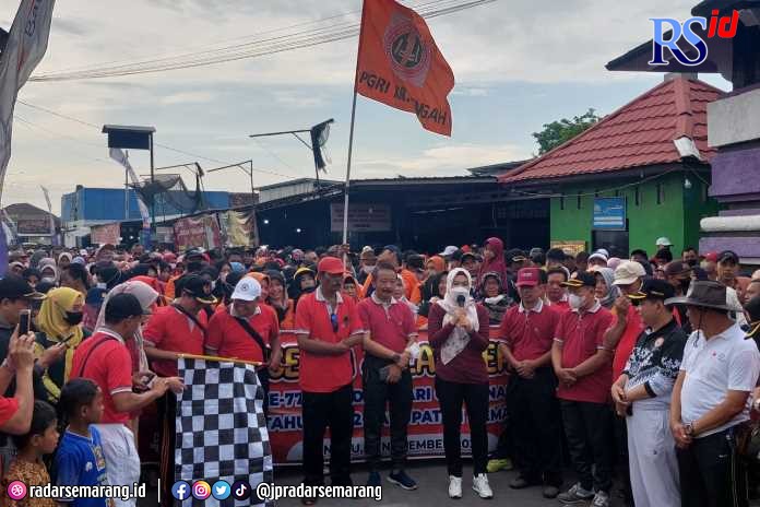 Bupati Demak dr Eistianah didampingi Ketua PGRI Demak H Sapon, MPd melepas jalan sehat HUT PGRI ke-76 dilapangan Tembiring. (Wahib Pribadi/Jawa Pos Radar Semarang)