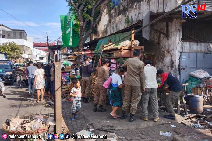 Petugas Satpol PP Kota Semarang, mengingatkan pedagang pasar tiban di kawasan Kranggan agar bisa tertib jam tayang. (ADENNYAR WYCAKSONO/JAWA POS RADAR SEMARANG)