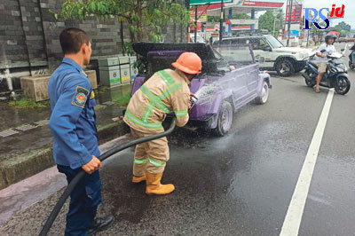 Petugas damkar saat memadamkan api yang muncul dari bagasi Volkswagen, Minggu (25/12). (Istimewa)