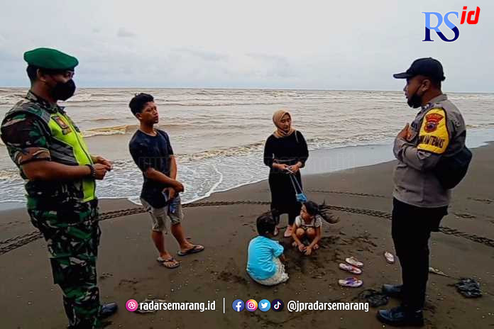 Antisipasi cuaca buruk, tim penyelamat terus memberi himbauan kepada pengunjung Pantai Jodo, Gringsing, Batang, agar berhati-hati, Minggu (26/12). (Lutfi Hanafi /Jawa Pos Radar Semarang)