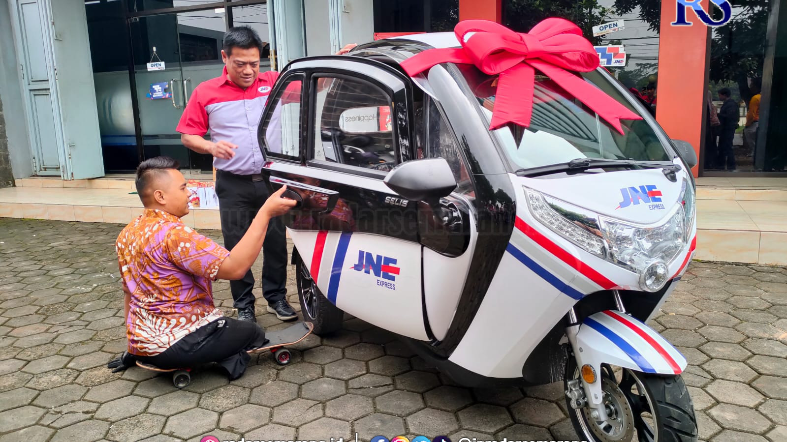 Guru disabilitas Mohamad Hikmat terlihat gembira saat menerima kendaraan listrik dari JNE. (RIYAN FADLI/JAWA POS RADAR SEMARANG)