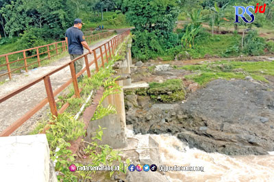 Kades Madugowongjati Edy Zaenuryanto melihat kondisi Jembatan Kali Belo yang mengkhawatirkan. (RIYAN FADLI/JAWA POS RADAR SEMARANG)