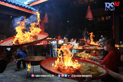Warga Tionghoa membakar kertas tengchi di atas tampah dalam sembahyang Toa Pek Kong Naik (Sang Sin) di Kelenteng Tay Kak Sie, Minggu (15/1). (NUR CHAMIM/JAWA POS RADAR SEMARANG)