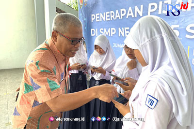 Kepala SMP N 15 Semarang Mohamad Hadi Utomo memberikan penghargaan pada Jastisya Vally Ayu Siffa Putri Alfath juara 1 Lomba MAPSI Rebana Tingkat Kota Semarang. (KHAFIFAH ARINI PUTRI/JAWA POS RADAR SEMARANG)
