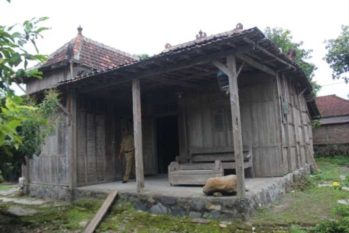 Gebyok dari kayu jati dengan logo Majapahit yang masih awet dan utuh tersimpan di rumah tua ini. (Anggi G/radar jombang)