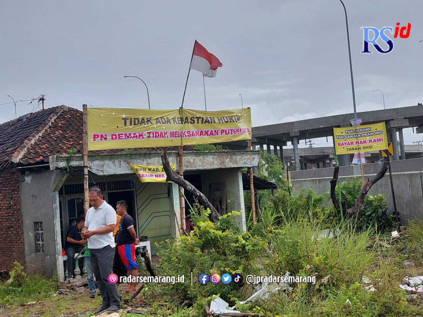 Sebuah baliho dipasang didepan rumah warga Desa Sidogemah, Kecamatan Sayung . Tepatnya diujung jalan exit tol Sayung. (Wahib Pribadi/Jawa Pos Radar Semarang)