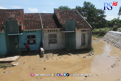 Warga Perumahan Dinar Indah Semarang membersihkan lumpur sisa banjir Minggu (20/2/2023). (Nurchamim/Jawa Pos Radar Semarang)