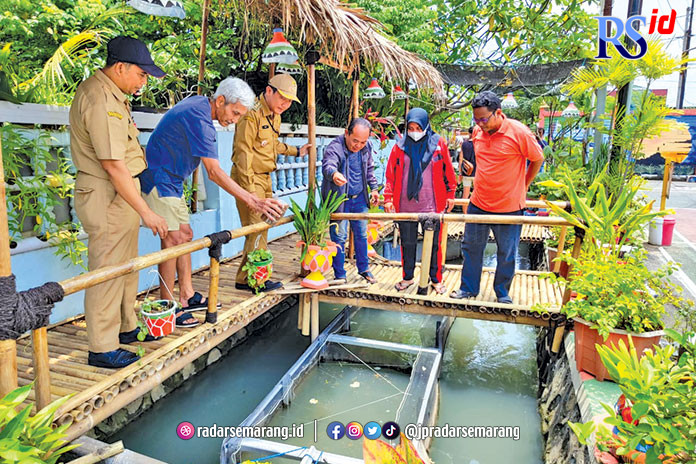 Lurah Pendrikan Lor R Wisnu Effendy bersama warga meninjau keramba di RW 5 dan memberikan makan ikan. (KHAFIFAH ARINI PUTRI/JAWA POS RADAR SEMARANG)