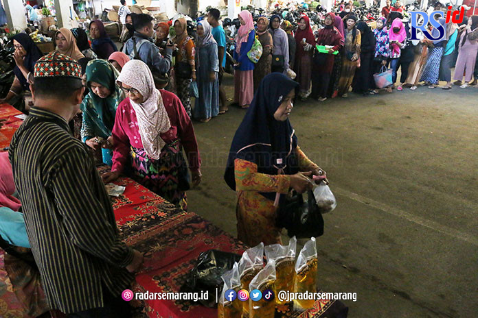 Ratusan warga dan pedagang antre membeli minyak goreng bersubsidi merek Minyakita dan Beras Medium saat operasi pasar yang digelar di Pasar Mranggen, Demak, kemarin. (NURCHAMIM/JAWA POS RADAR SEMARANG)
