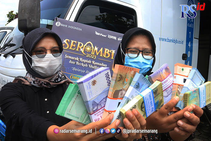 Dua warga menunjukkan uang baru dalam peluncuran Program SERAMBI di halaman kantor Bank Indonesia Jalan Imam Barjo Semarang, Senin (27/3). (Nurchamim/Jawa Pos Radar Semarang)