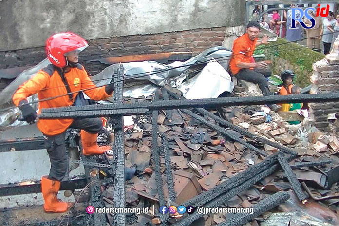 Petugas membersihkan puing-puing rumah milik Rohman yang luder terbakar. (Istimewa)